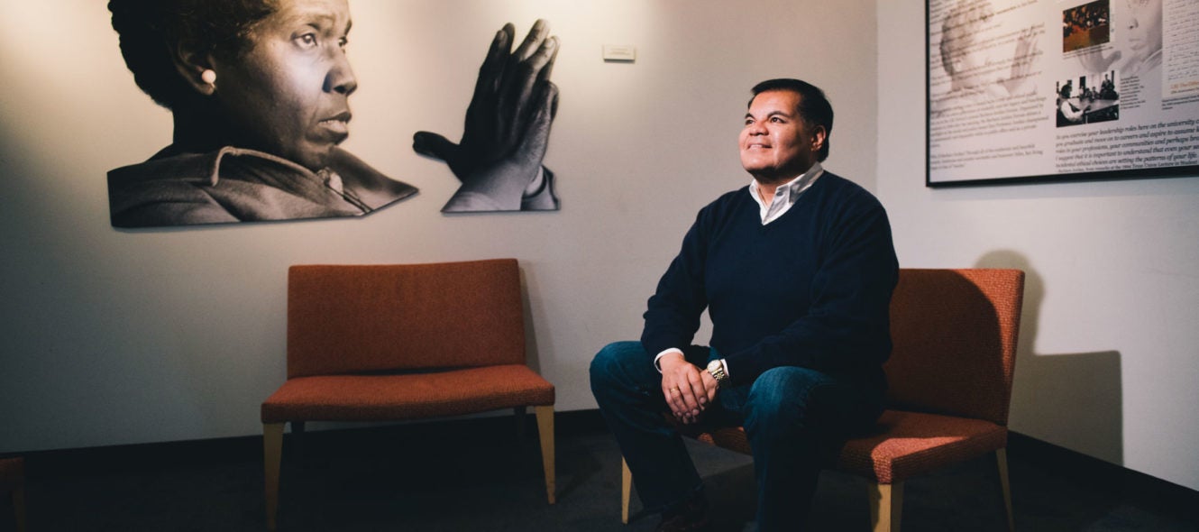 Mario Espinoza sitting next to Barbara Jordan mural