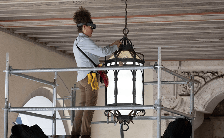 A worker adjusting a lighting fixture.