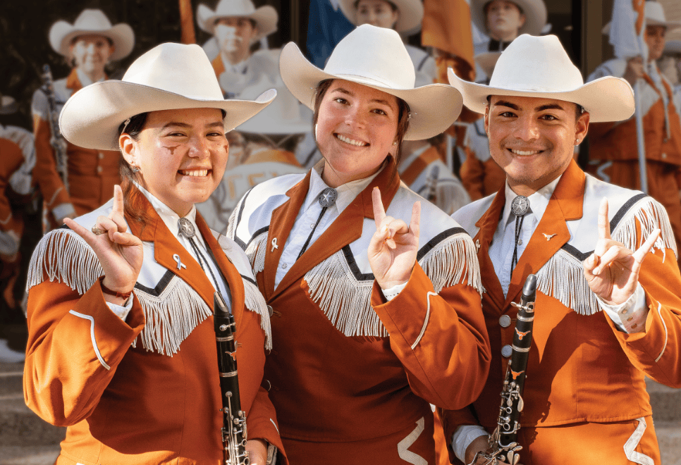 Three UT Band members gesturing hook'em horns