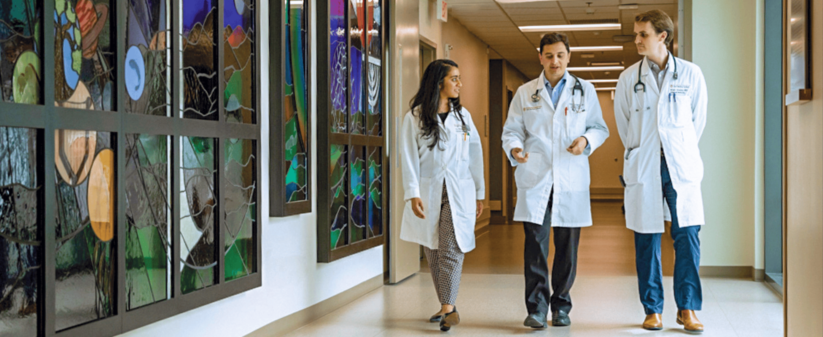 Three medical professionals walking down a hallway