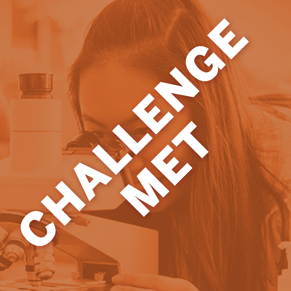 Image of student looking through a microscope. The graphic has a burnt orange overlay with white text stating "Challenge Met."