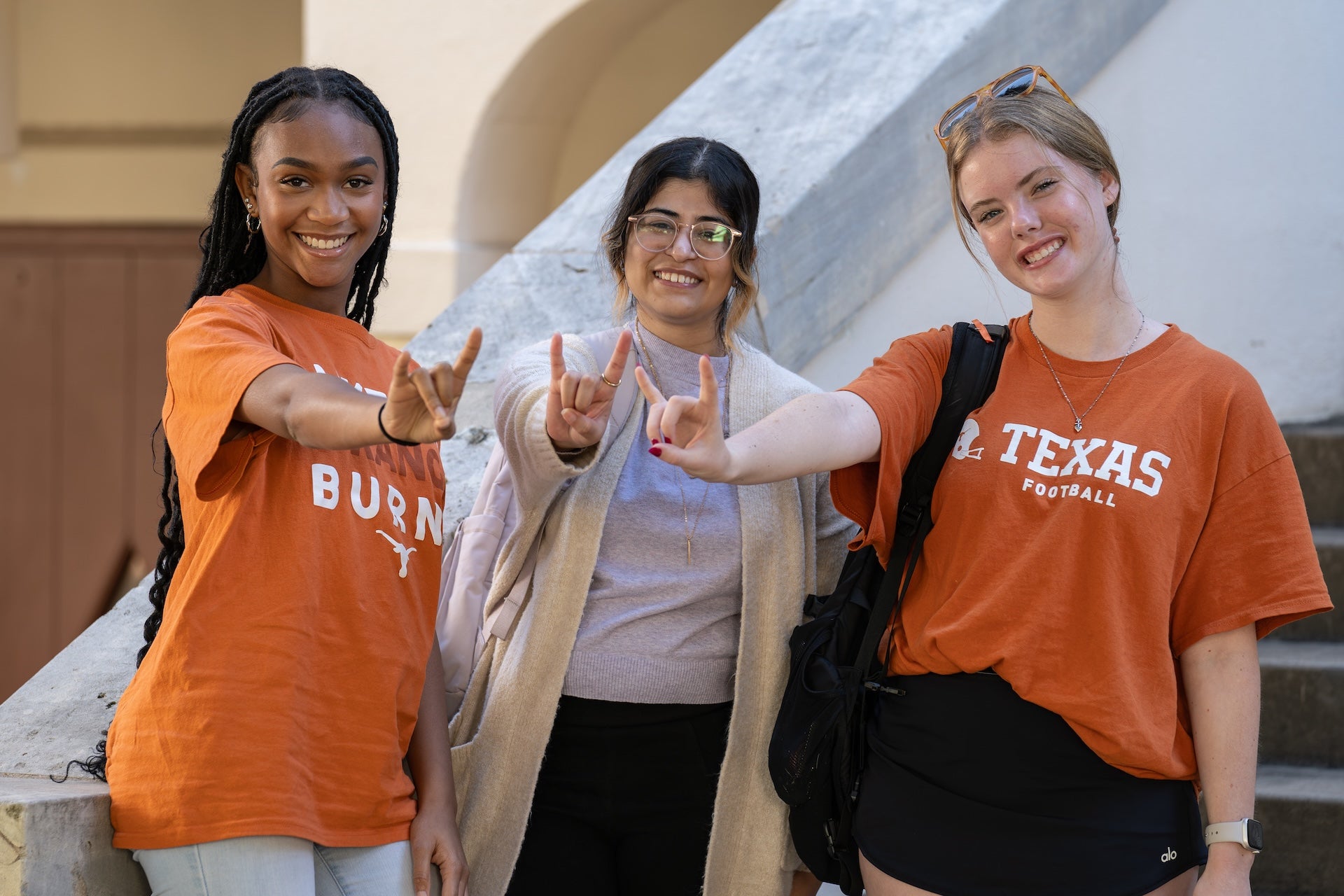 Rivalry Challenge UT fans gesturing Hook'em Horns.